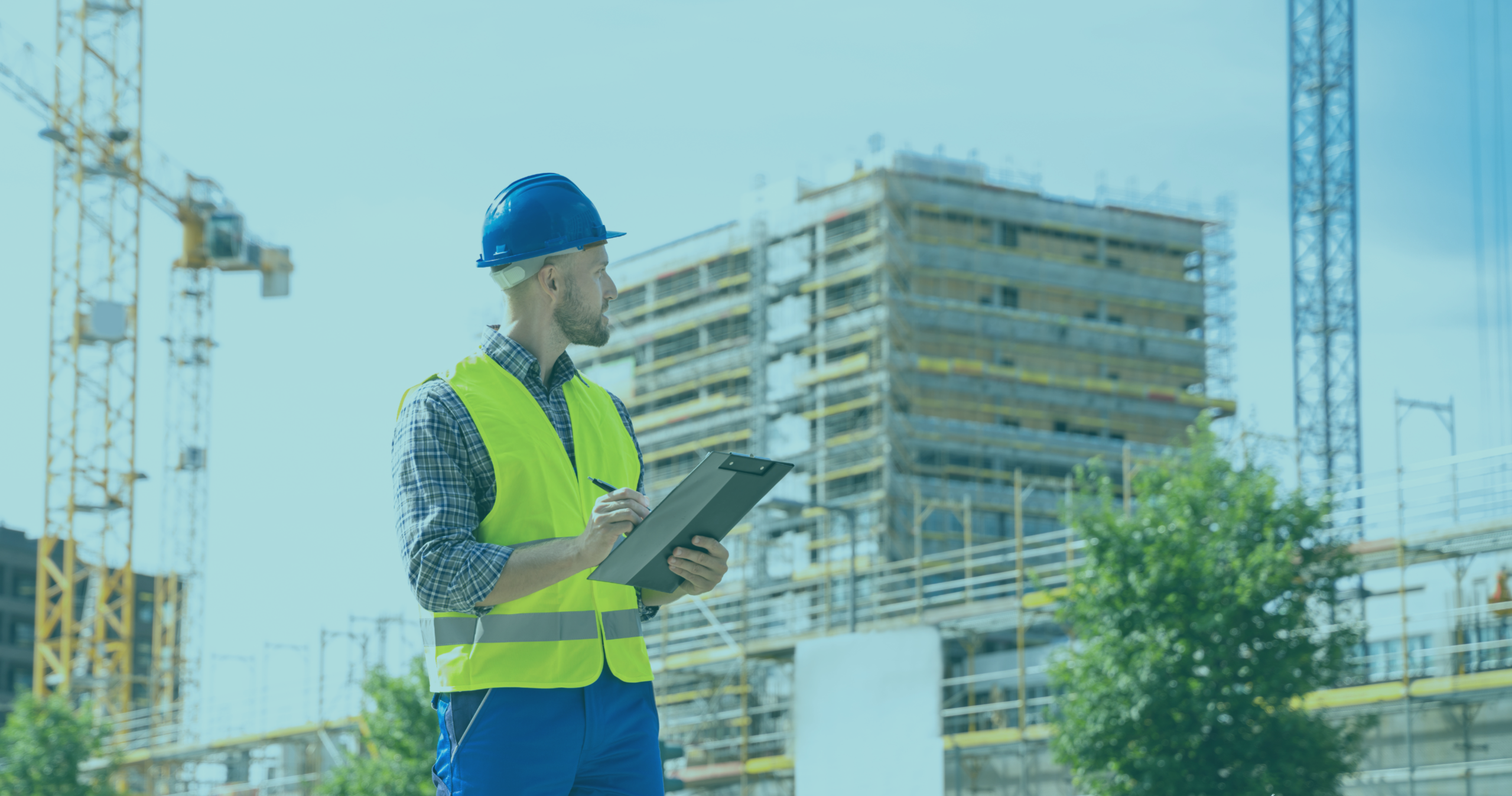 Clerk of Works reviewing inspection notes on a clipboard in front of a high-rise building under construction, illustrating independent site inspection during new-build residential construction.