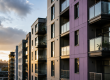 Residential apartment buildings with external cladding photographed at sunset, used to suggest the need for cladding remediation on high-rise buildings across the UK.