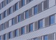 Close-up of cladding panels and windows across multiple floors of a residential building.