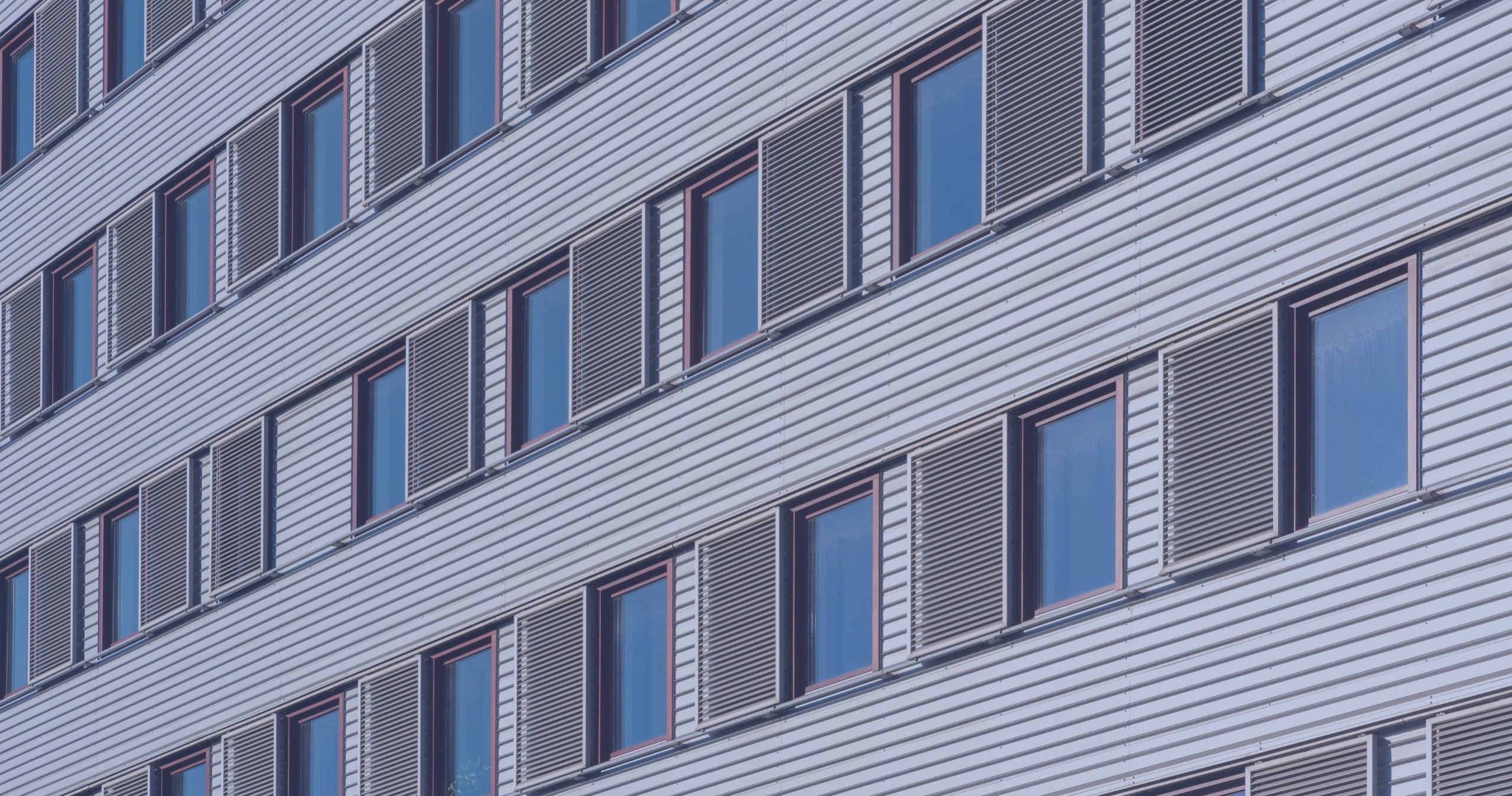 Cladding panels and windows on a multi-storey residential building Close-up of cladding panels and windows across multiple floors of a residential building.