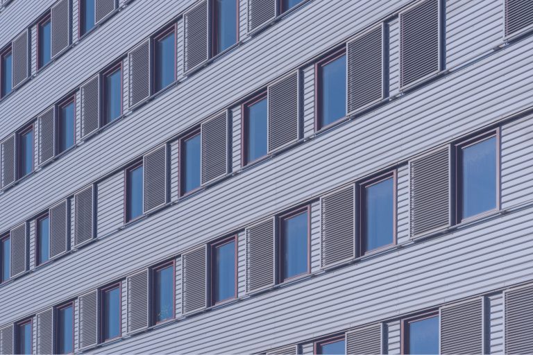 Close-up of cladding panels and windows across multiple floors of a residential building.